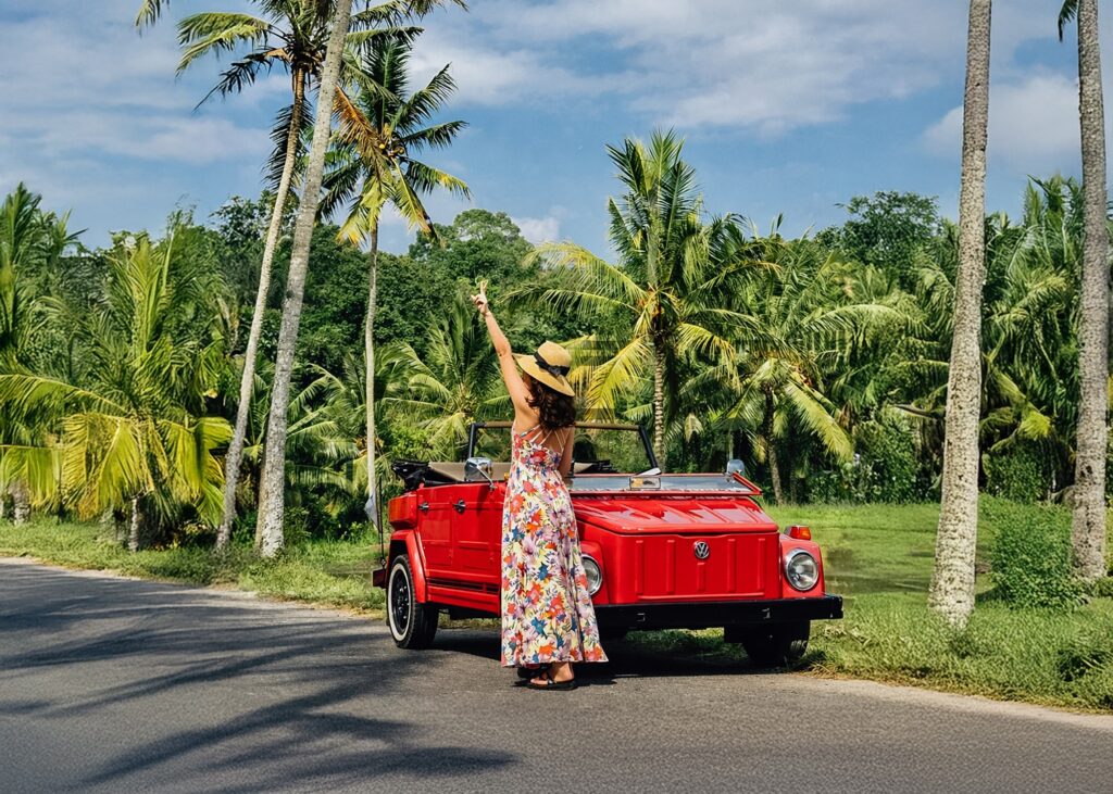 Women posing with a classic Volkswagen at Pertiwi Adventure Bali during the Majestic VW Tours experience