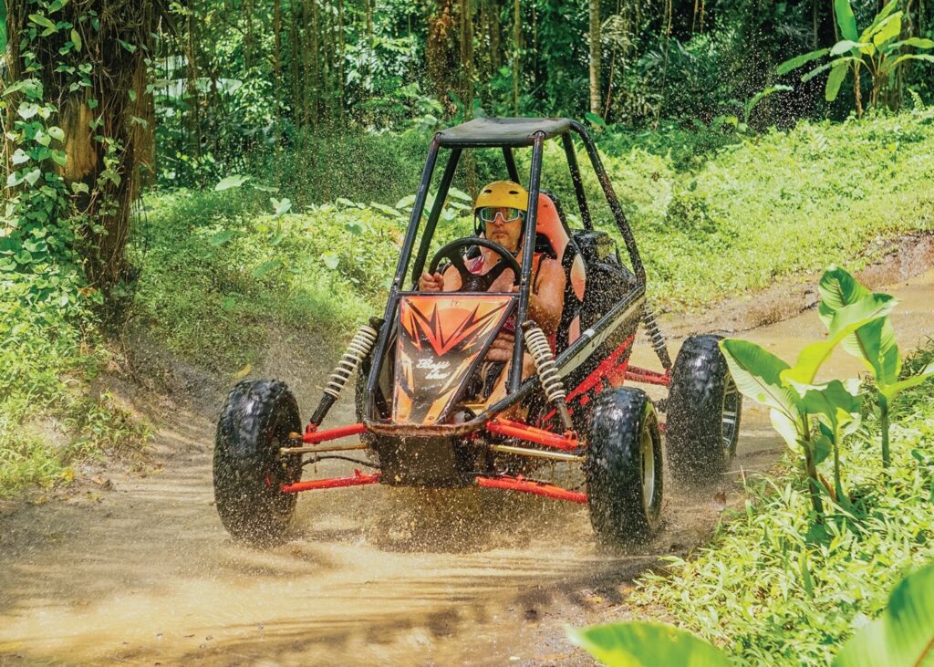 Guests riding a UTV jungle buggy through tropical forest trails at Pertiwi Adventure Bali