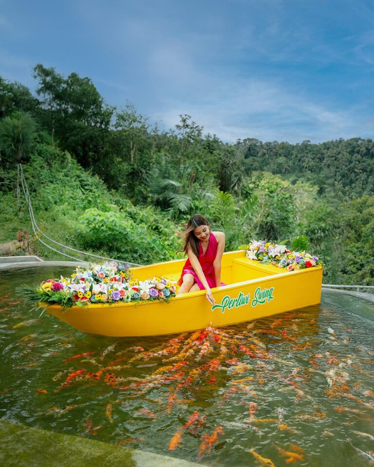 Koi pond boat experience at Pertiwi Jungle Swing surrounded by lush tropical garden scenery